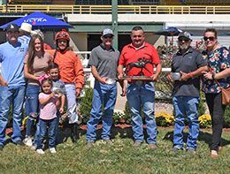 The winning connections of Chief Iron Eagle accept the Cricket Bar Futurity stakes trophy at Will Rogers Downs.