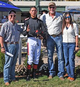 The winning connections of Wire Tap accept the $15,000 Henry Bowlan Memorial Stakes trophy at Will Rogers Downs on Monday.