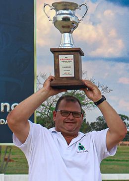 Trainer Flavio Melo lifts the winning trophy at Sorocaba Racecourse.