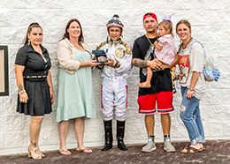 The winning connections of Blood Kiss accept the Louisiana Starter Stakes trophy at Delta Downs on Saturday.
