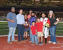 The winning connections of Sign Of A Jet accept the Silver Bullet Stakes trophy at Retama Park on Thursday.
