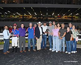 The winning connections of The Valiant Flame accept the $58,344 Adequan Sam Houston Derby trophy at Sam Houston on Saturday.