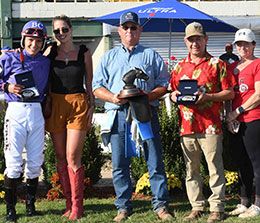 The winning connections of Kowboy Boogie accept the John Deere Will Rogers Juvenile Challenge stakes trophy on Sunday.