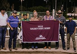 The winning connections, EG High Desert Farm, accept the Golden State Derby stakes trophy at Los Alamitos Race Course.
