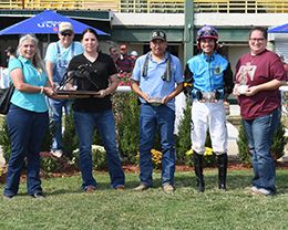The winning connections of Kung Fu Express accept the Cricket Bar Futurity trophy at Will Rogers Downs on Monday.