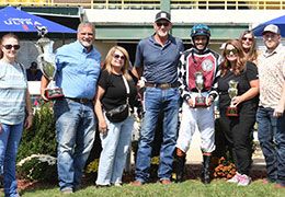 The winning connections of Flight Risk accept the Pot O Gold Futurity stakes trophy on Monday.