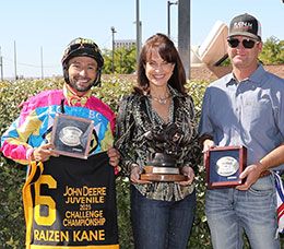 AQHA Chief Racing Officer Jane VanBeber presents the John Deere Juvenile Challenge Championship trophy to winning jockey Ramiro Garcia and trainer Jason Olmstead at Albuquerque Downs Sunday.
