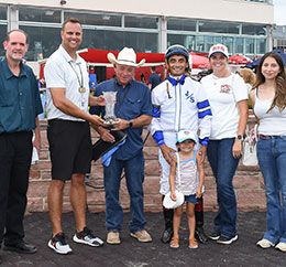 The winning connections of Curls Magic Wagon accept the Keokuk Stakes trophy at Prairie Meadows Friday evening.