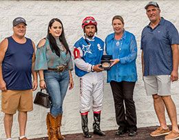 The winning connections of One Fast Cajun accept the Live Oak Stakes trophy.
