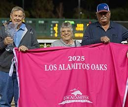 Owner James Sills and trainer Eddie Willis accept the Los Alamitos Oaks stakes trophy Saturday night at Los Alamitos Rae Course