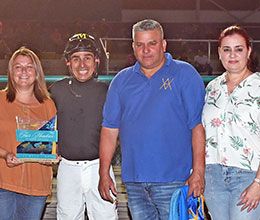 The winning connections of Burning Follies accept the Golden Driller Stakes trophy Saturday night at Fair Meadows.