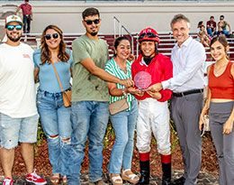The winning connections of Jes Winnin Cartel accept the Audubon Stakes trophy.