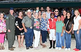 The winning connections of Leavinematthebar accept the Gary Baber Memorial Stakes trophy at Retama Park.