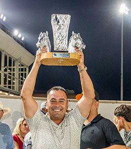 Owner Jaime Cardenas hoists the LQHBA Sale Futurity stakes trophy in the air at Delta Downs Saturday night.