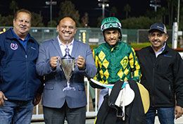 Marketing Director Orlando Gutierrez presents the Las Damas stakes trophy to Paul Jones, Henry Reynoso Lopez, and Roque Conzalez.