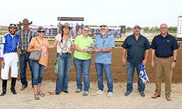 The winning connections of Apollitical Mission accept the Leader Of Class Sale Futurity stakes trophy.