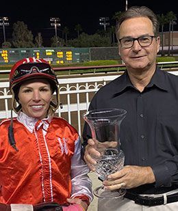 Bob Hurd presented the Town Policy Stakes trophy to jockey Justine Klaiber at Los Alamitos Race Course.