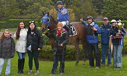 The winning connections of Had To Be Fabulous accept the QROOI Open Derby stakes trophy.