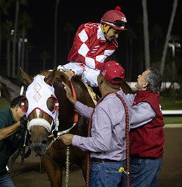 Trainer Chris O'Dell congratulates jockey Jesus Rios Ayala on Sunday night.