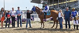 The connection’s of Imaginacion, including jockey Edwin Escobedo, trainer Joe Davis and owner Kaylee Escobedo, accept the trophy after winning the Energy Downs Maturity on Saturday afternoon