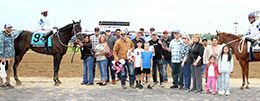 The winning connections of Tachas Secret and High Rolling Seize join together to accept the 84,000 Born Runner Classic trophy after winning in a dead heat at Horseshoe Indianapolis on Saturday.
