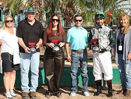 The winning connections of Wicked Cowgirl Smart accept the Wayne Brasher Memorial Stakes trophy at Turf Paradise Racetrack.