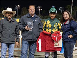 Roque Gonzalez, Paul Jones, Henry Lopez and Marian Jones accept the Charger Bar Handicap stakes trophy at Los Alamitos Race Course.
