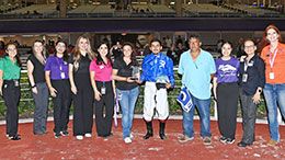 The winning connections of Karma Cha Ching accept the La Villita Stakes trophy at Retama Park on Thursday.