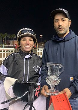Jockey Justine Klaiber and assistant trainer Albert Valle accept the A Ransom Stakes trophy on Saturday night.