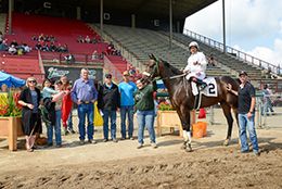 The winning connections of Getit Foose accept the $15,549(US) Grand Prairie Distance Stakes trophy at Evergreen Park on Sunday.