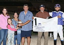 Jessica Cummings, VP of Operations for Lip Chip presents the winning owner Mauricio Garza, trainer Roy Garza, and jockey Edgar Mata the King William Stakes trophy at Retama Park Saturday.