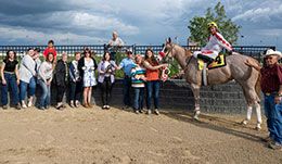 The winning connections of First Famous Prize accept the Adequan Derby Challenge stakes trophy at Century Mile.
