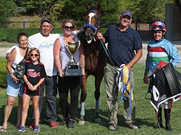 The winning connections of Queen Charlotte accept the $22,706 (US) Princess Maturity trophy at Ajax Downs on Wednesday.