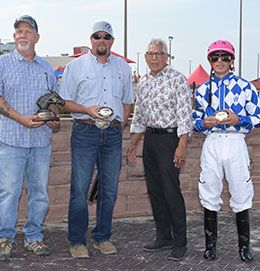 The winning connections of One Fabulous Boy accept the AQHA Prairie Meadows Championship Challenge stakes trophy.