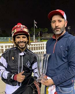 Eduardo Nicasio and Albert Valles accept the La Pacifica Handicap stakes trophy Saturday night at Los Alamitos Race Course.