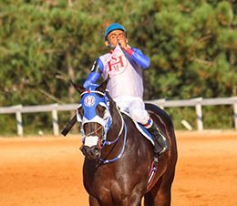 Jockey Ronaldo Pereira kisses the silks and gets emotional after winning the II Derby.
