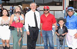 The winning connections of Karmalites accept the Four Corners Futurity stakes trophy.