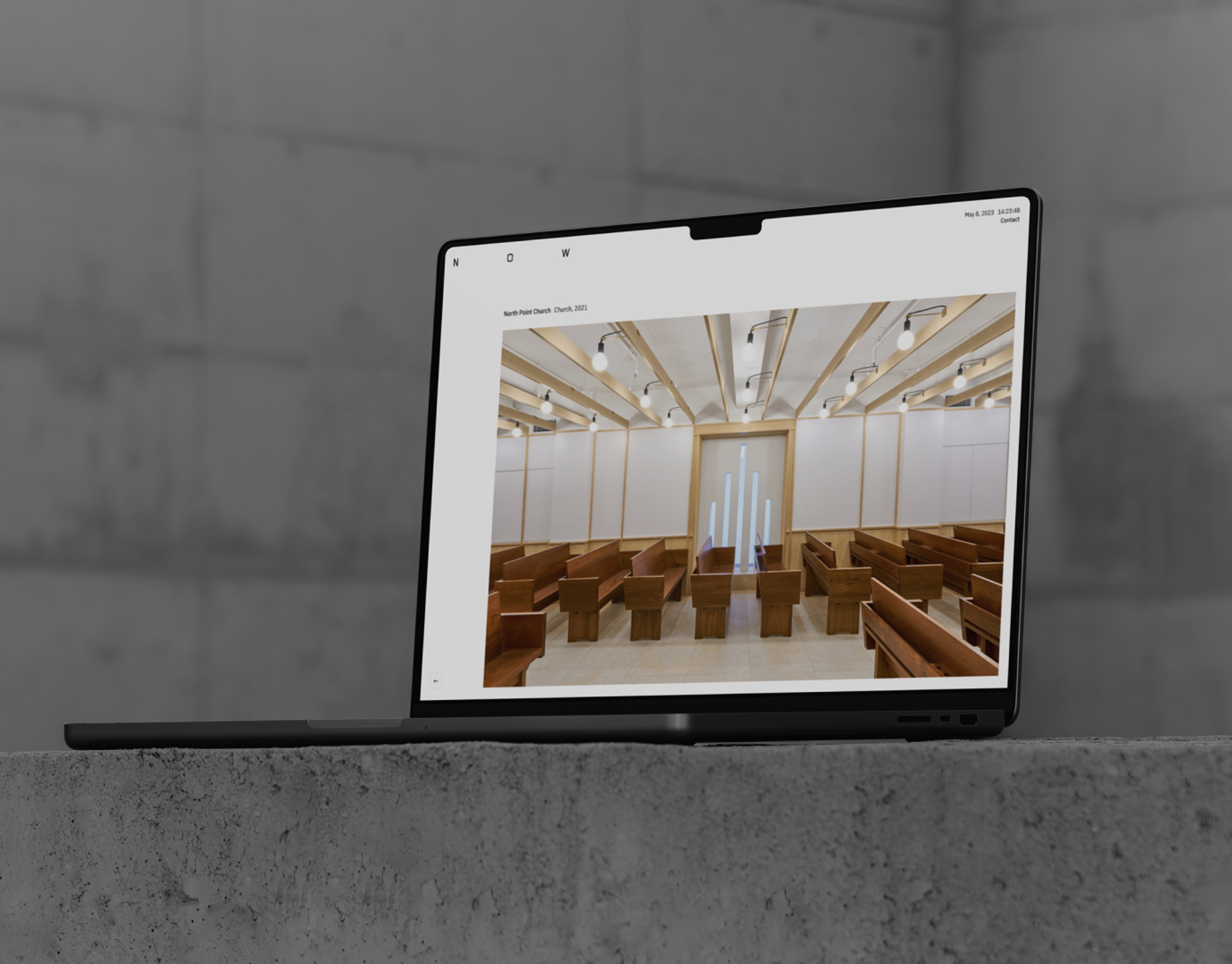 A laptop sat on a concrete block displaying the North Point Church project on the website of New Office Works