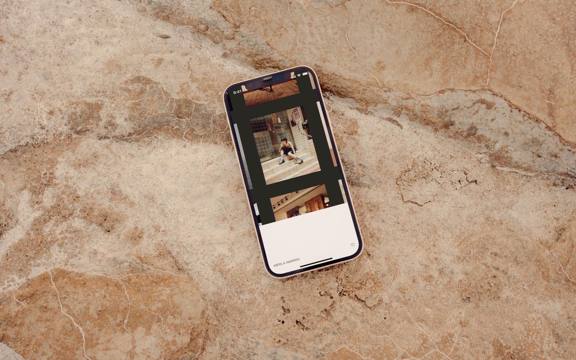 iPhone laying on a marble surface displaying the Abdela Igmirien portfolio project