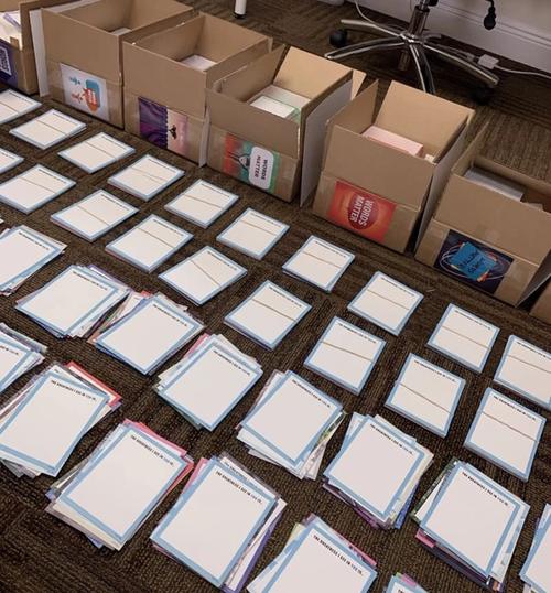 Papers in stacks on floor in front of cardboard boxes