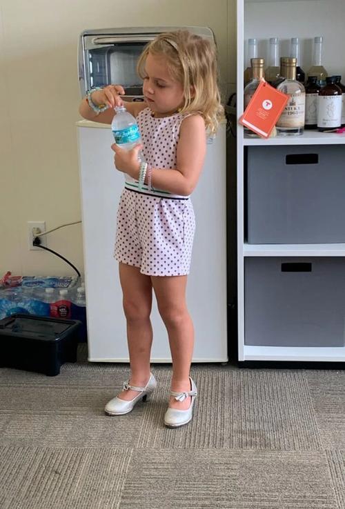 Young girl in office with bottle of water