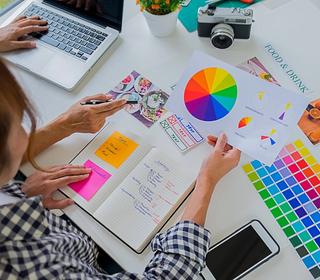 Woman holding color swatch while they plan marketing campaign strategy