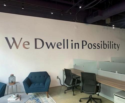 Office wall that says "we dwell in possibility"
