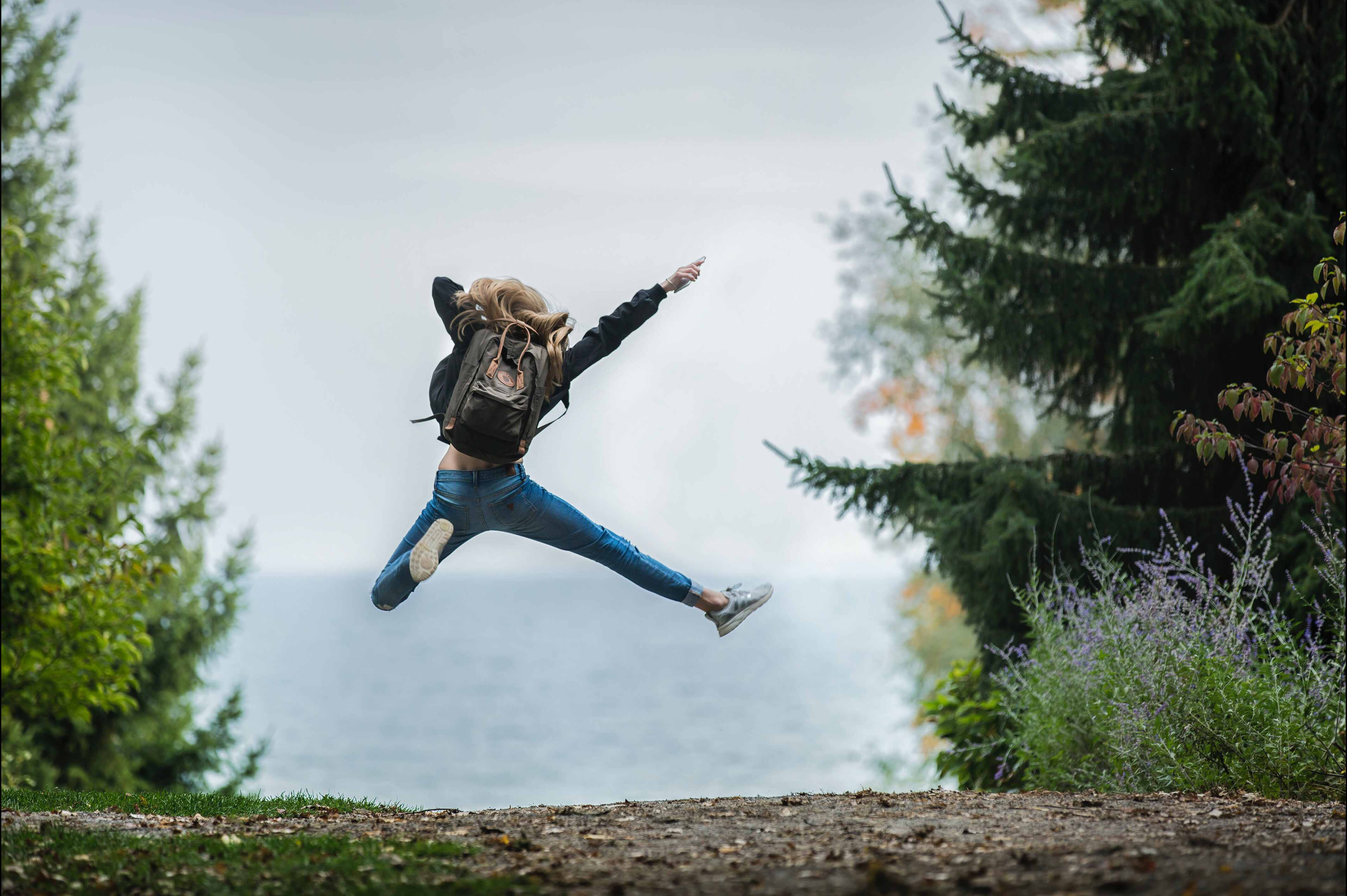 Woman jumping in the middle of the forest.