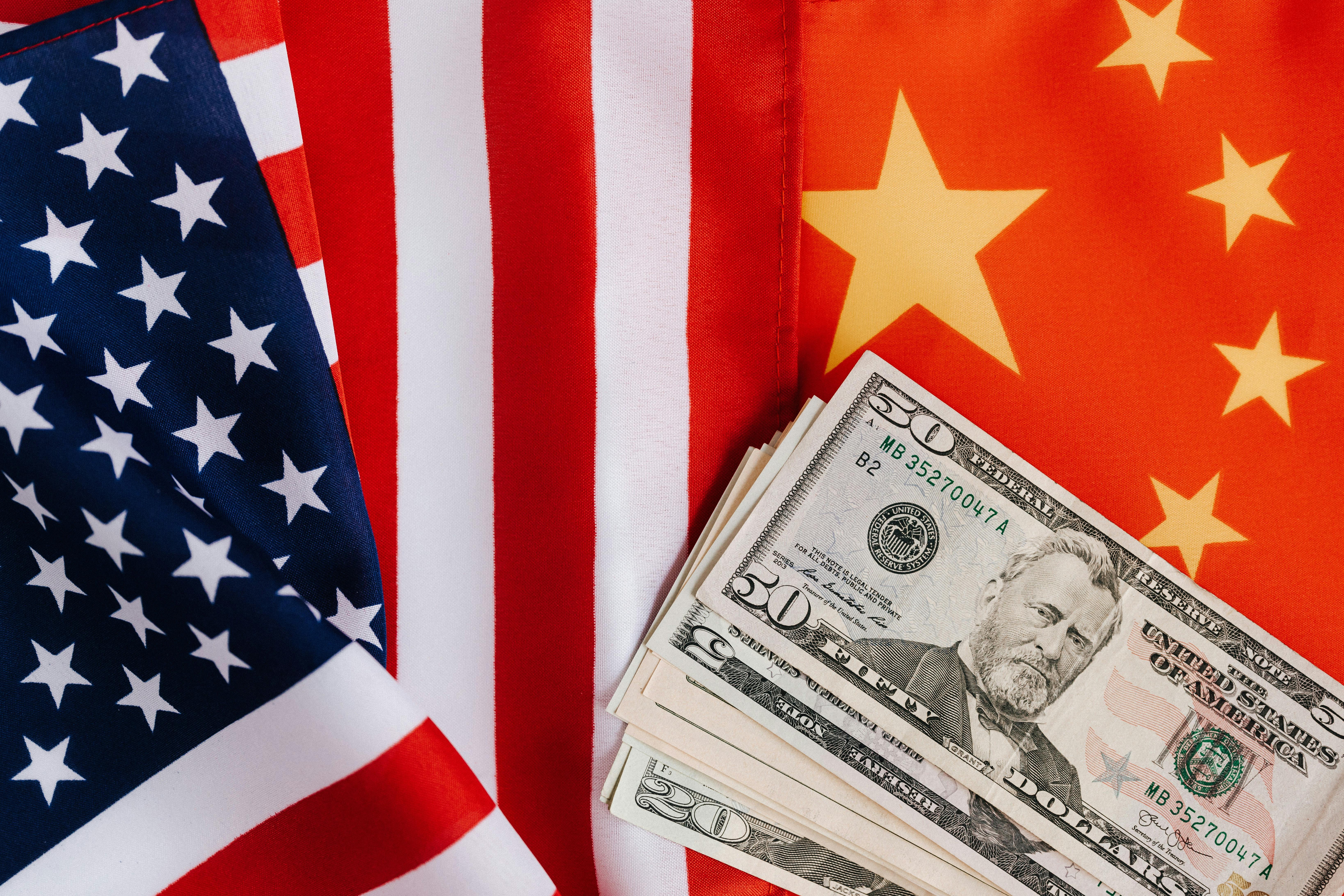 US and China flags with dollar notes superimposed