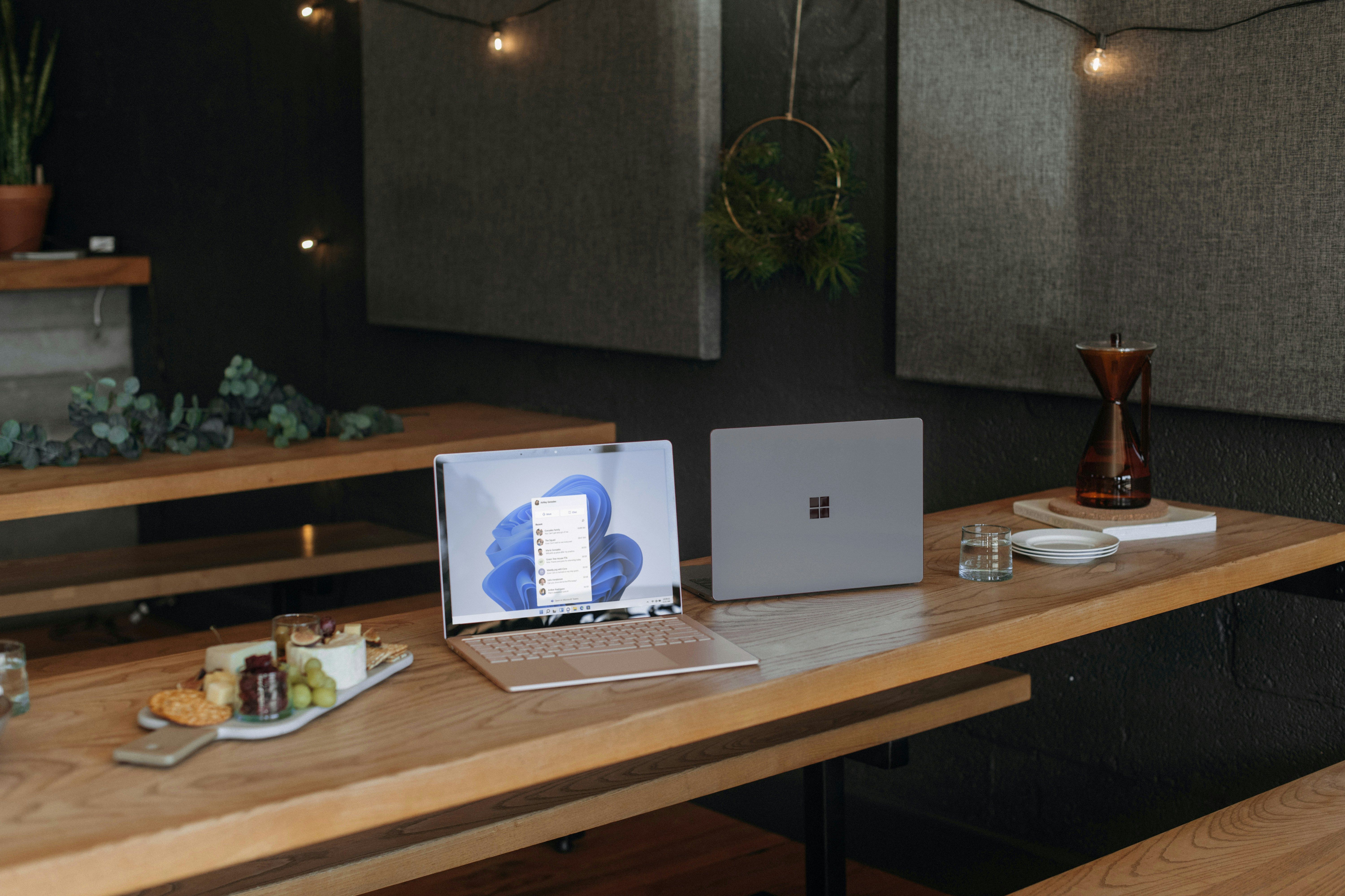 Two Microsoft laptops on a table in an office