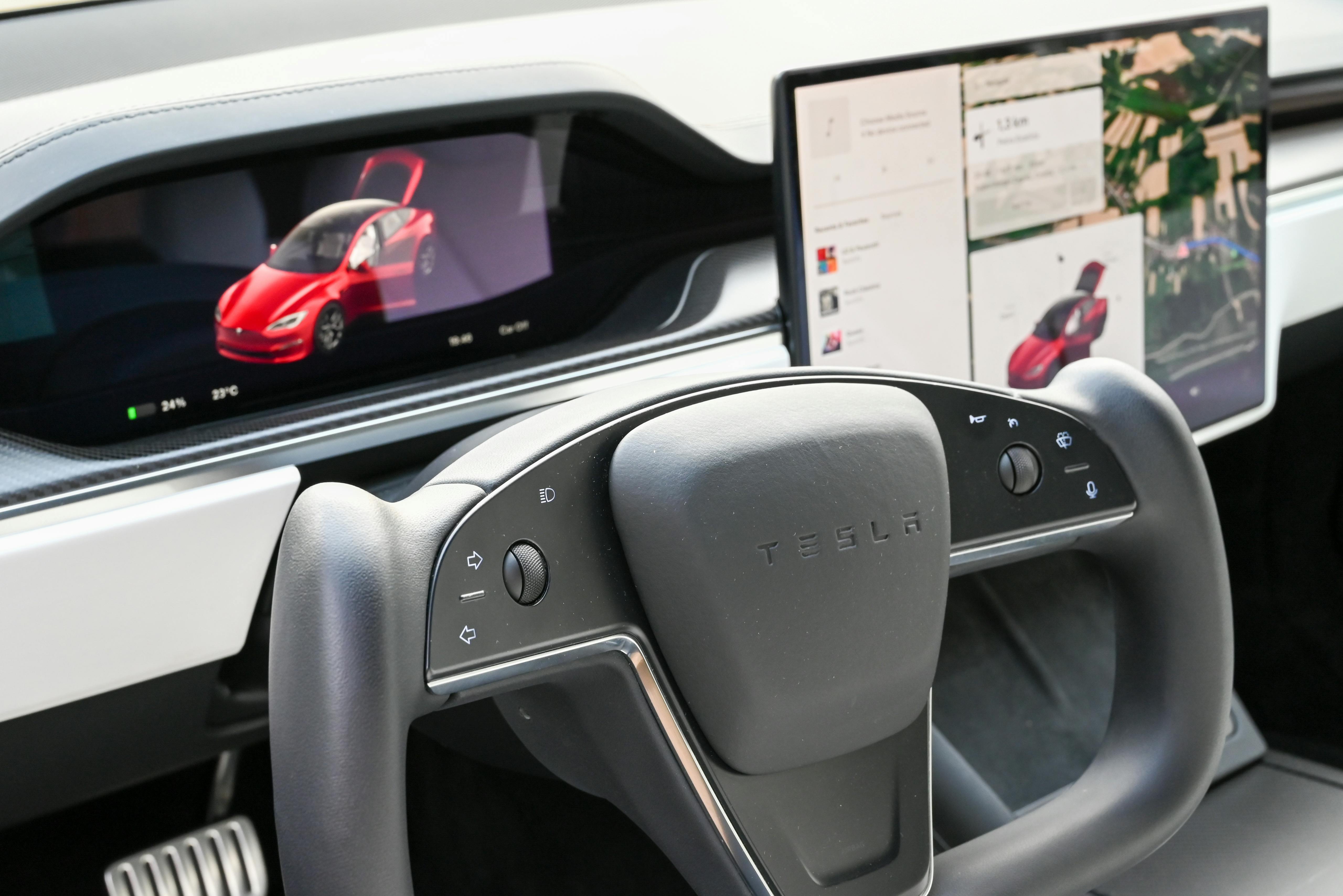 Main Image: Interior of a Tesla car showing the dashboard