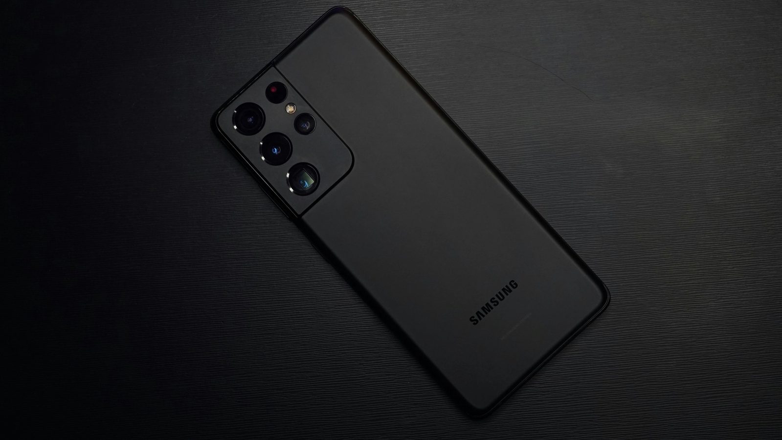 Main Image: Black Samsung Galaxy S21 on a black surface