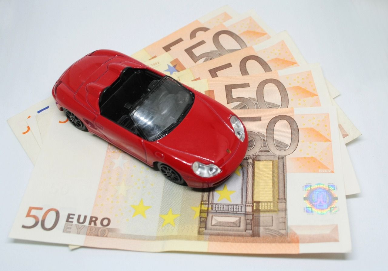 A toy Ferrari on top of a stack of Euro notes