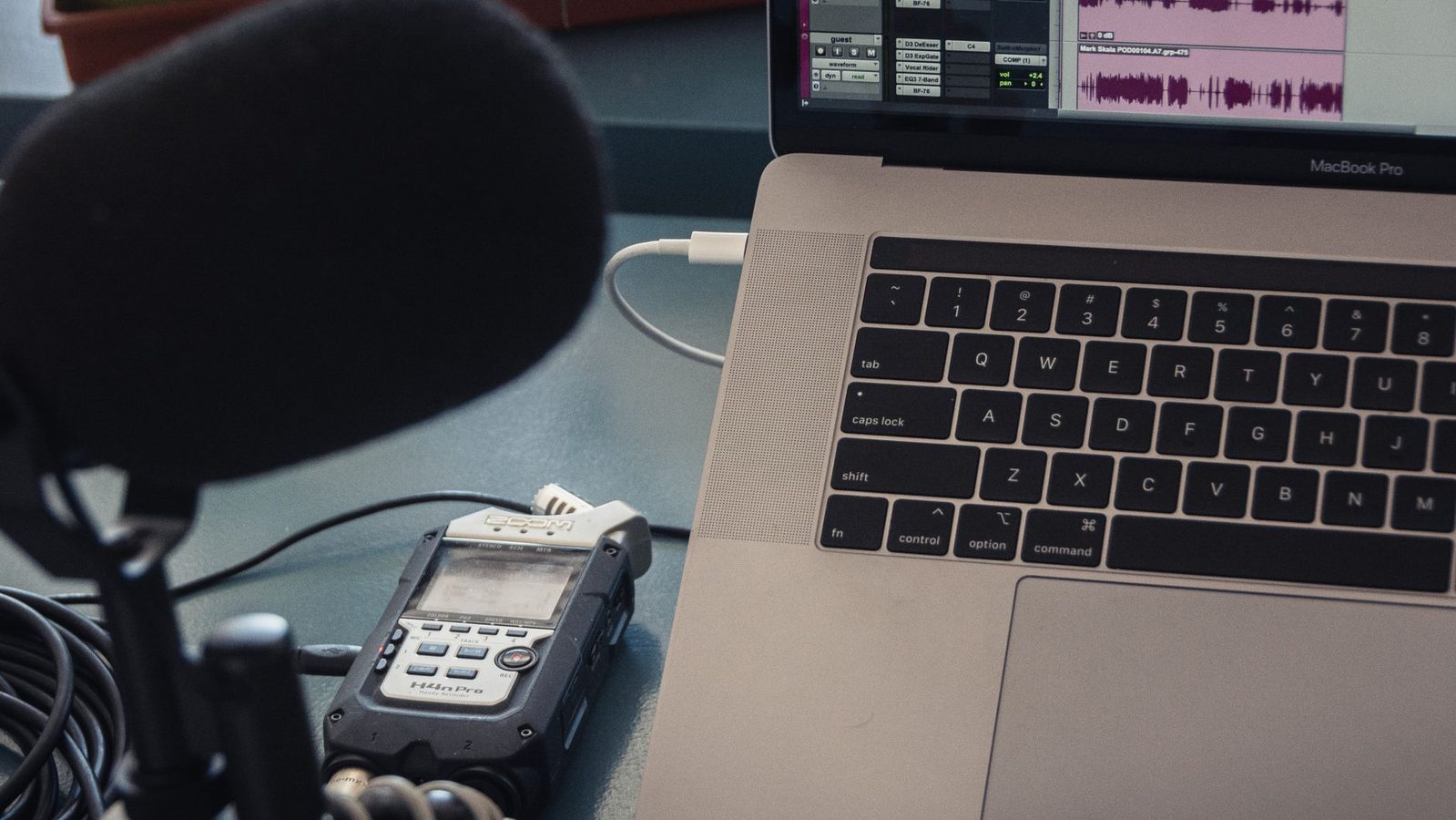 A microphone beside a laptop on a desk